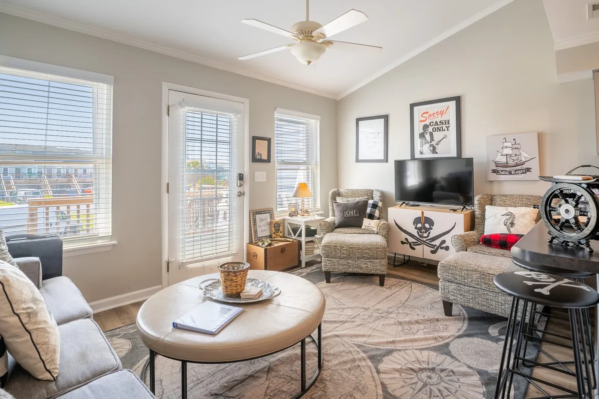 A playful, cozy seating nook with pirate-themed decor, large sunlit windows, and a coffee table set for conversation or games. The area feels bright and welcoming, inviting guests to relax or gather for activities.